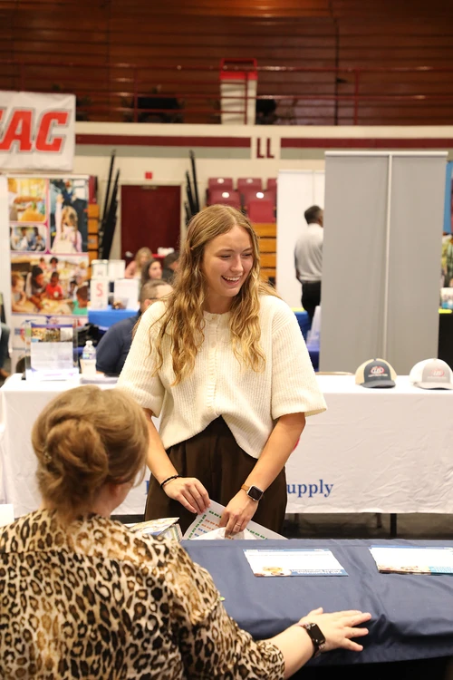 woman smiling and networking at booths